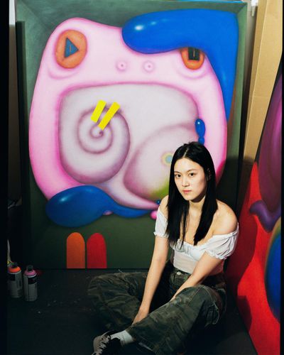 Nianxin Li posing in front of her work Frog doesn’t notice blue (2022). Acrylic on canvas. 60 x 48 inches.