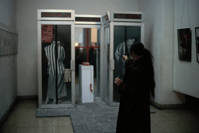 Xiao Lu, Dialogue (1989). Installation and performance. Two telephone booths, paint on glass, mirrors, telephone, bricks, and pistol. 240 x 270 x 90 cm.