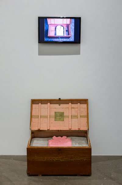 Yin Xiuzhen, Dress Box (1995). Wooden trunk with adhered paper, clothes, cement, and bronze plaque. 38 x 67 x 44 cm. Colour video with sound. 21 min 31 sec. M+ Sigg Collection, Hong Kong, by donation.