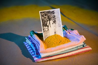 Shivanjani Lal, Khet (2018). (Detail) Mixed media installation, turmeric hand-died cloth, turmeric circle, brown paper, saris from women in the artist’s family, photographs from the artist’s Grandmother’s archive. Exhibition view: Between Suns, Cement Fondu, Sydney (21 July–16 September 2018). Courtesy the artist and Cement Fondu. Photo: Anna Kucera.