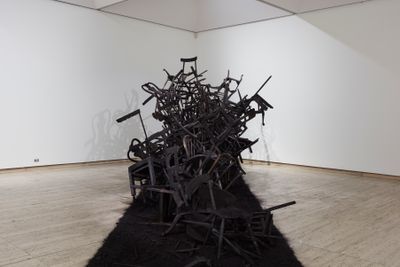 Rushdi Anwar, Irhal (Expel), Hope and the Sorrow of Displacement (2013–ongoing). Burnt wooden chairs, black oxide pigment, charcoal, ash. Dimensions variable. Exhibition view: The National 2019: New Australian Art, Art Gallery of New South Wales, Sydney (29 March–21 July 2019). © Rushdi Anwar. Courtesy the artist. Photo: AGNSW, Mim Stirling.