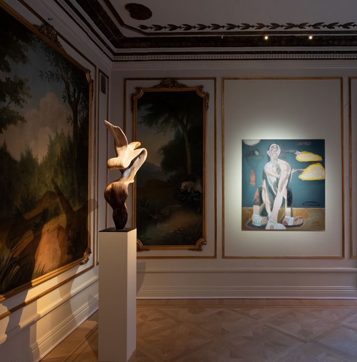 An abstract, curved sculpture is placed on a plinth in the gallery class=