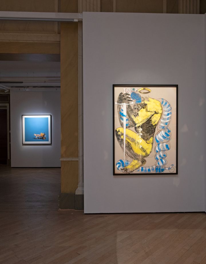a painting of a crouched figure holding a sword is showing in the gallery class=