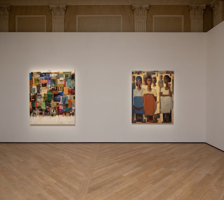 Patches of colour are rendered on a painting on a wall in the gallery space, which sits alongside another painting showing a group of women class=