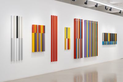 Exhibition view of Liam Gillick's exhibition showing 7 artworks of vertical strips, mostly colourful panels