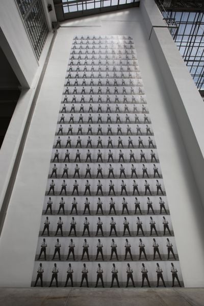220 black and white prints showing man in white shirt stacked in a large grid.