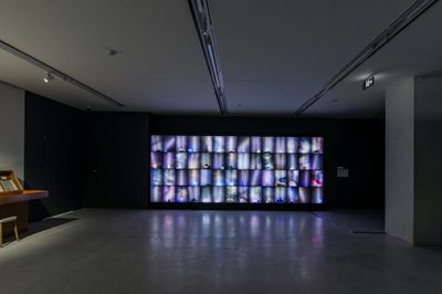 A Lightbox installation by Shi Yong features stacked screens in a darkened exhibition space.