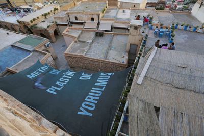 Merve Ünsal, A few words to drones (2022). Site-specific, text printed on awning tarp. Exhibition view: 5th Mardin Biennial, The Promise of Grass, Mardin (20 May–20 June 2022).