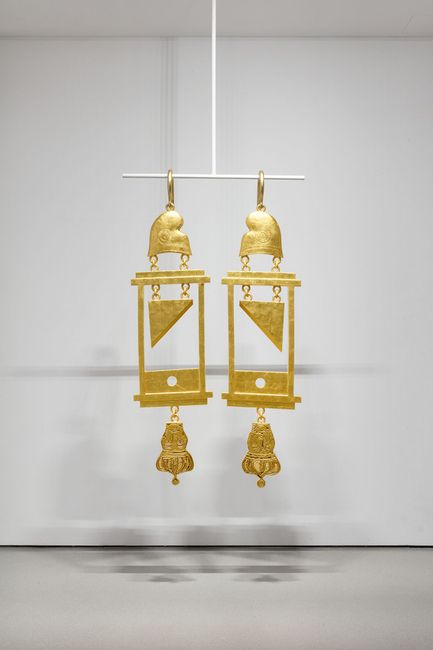 A Dramatically Enlarged Set of Golden Guillotine Earrings Depicting the Severed Heads of Marie Antoinette and King Louis XVI by Simon Fujiwara contemporary artwork