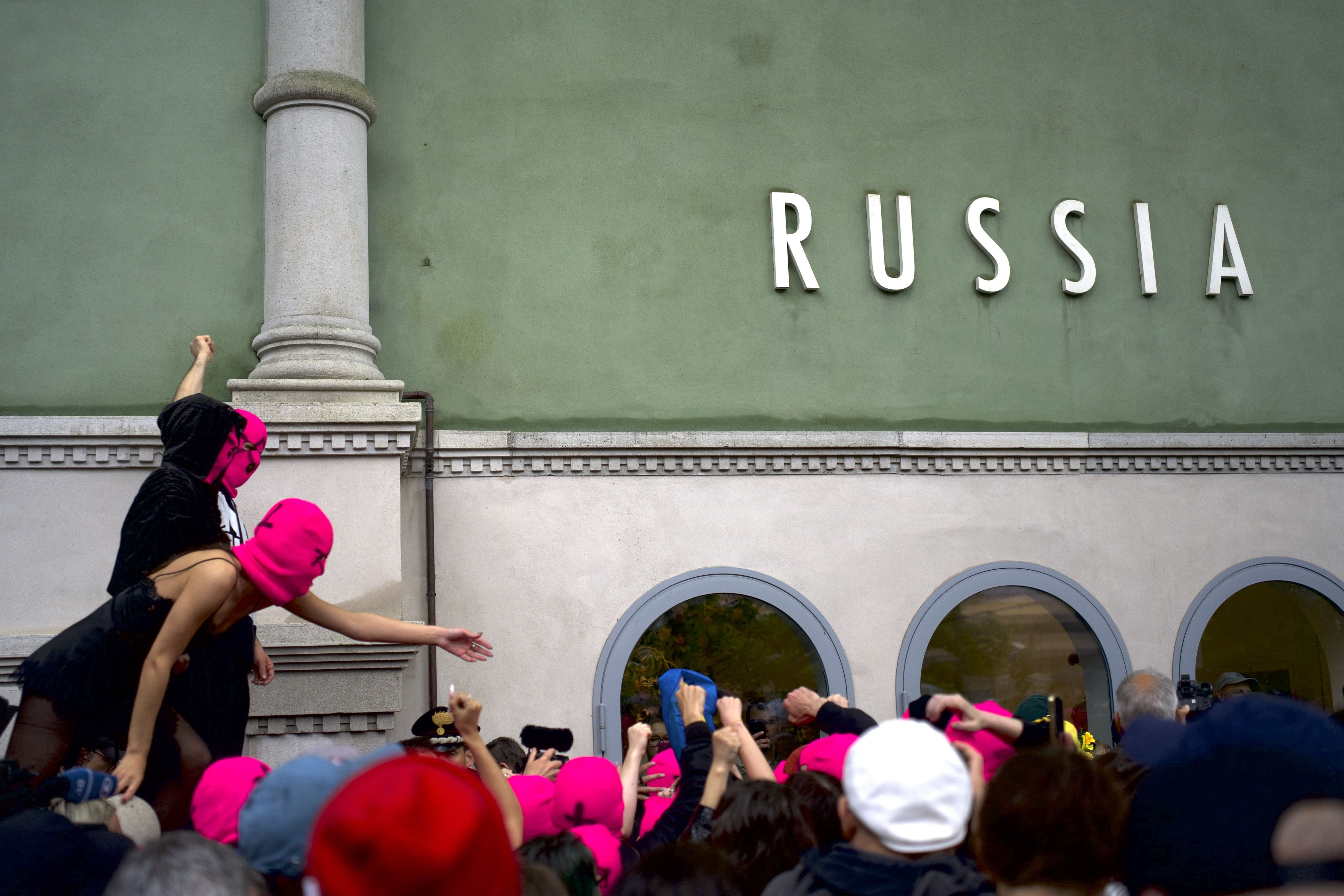 Pussy Riot members reveal painted slogans during a protest staged outside the Russian pavilion at the 61st Venice Biennale (2026).
