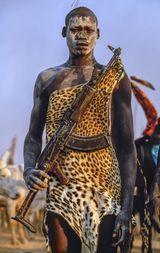 Dinka Warrior with Leopard Skin and Kalashnikov Rifle South Sudan by Carol Beckwith  Angela Fisher contemporary artwork print