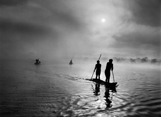 At daybreak Waura Indians travel by canoe to collect the waiting net Xingu Indigenous Territory state of Mato Grosso Brazil by Sebastiao Salgado contemporary artwork Photography