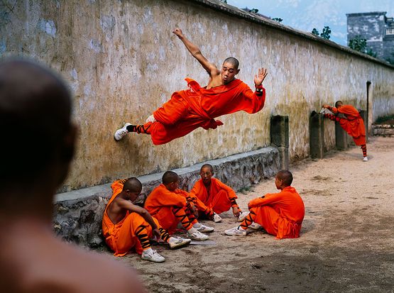 A young monk runs along the wall over his peers at theShaolin Monastery in Henan Province China by Steve Mccurry contemporary artwork Print